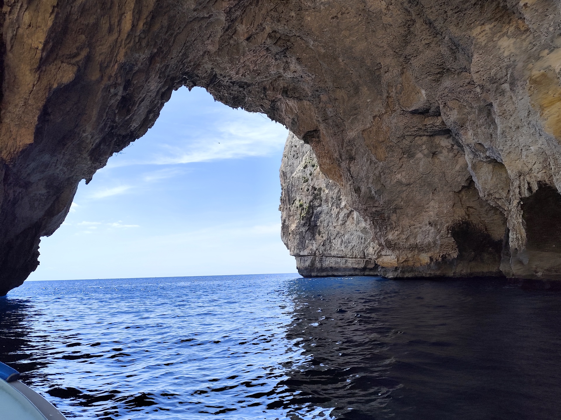 Grande arco rochoso da Blue Grotto visto de um barco, aberto para o mar e o céu em Malta