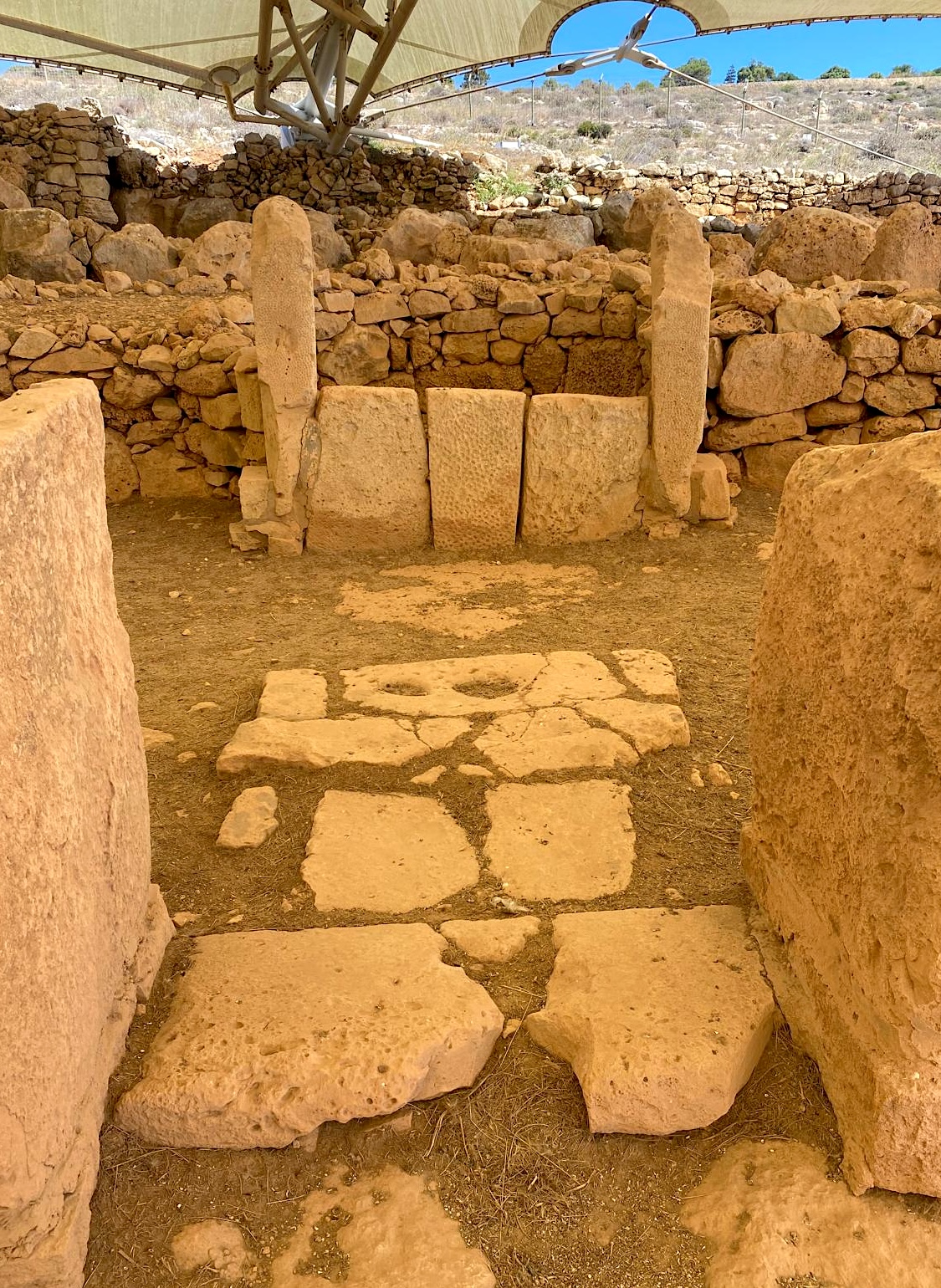 Abside et dalles d’autel décorées de Ħaġar Qim Abside du temple de Ħaġar Qim avec ses dalles d’autel décorées, pierres dressées et dallage ancien sous le ciel maltais