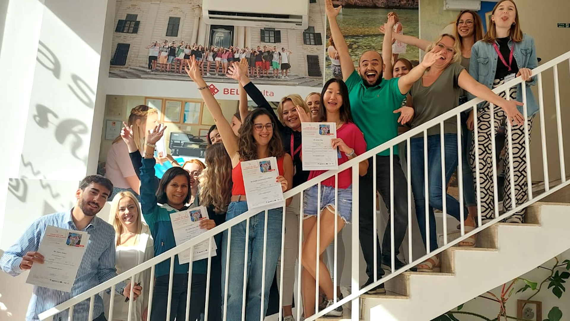 Entrega de certificados en BELS Malta Estudiantes de BELS Malta con sus certificados en la escalera