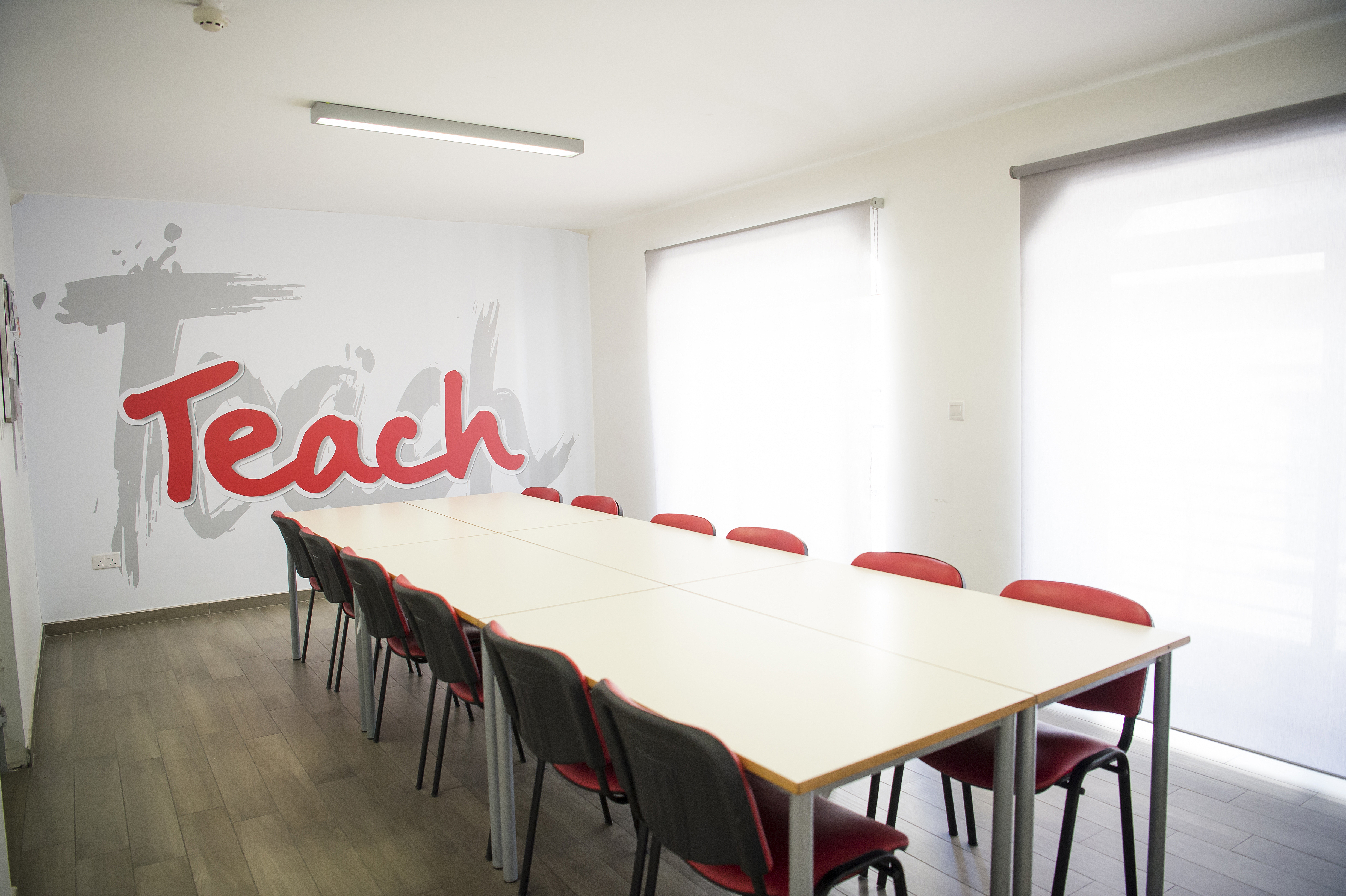 Salle de classe d’IELS Malta Salle de classe d’IELS Malta avec la fresque « Teach » et chaises rouges