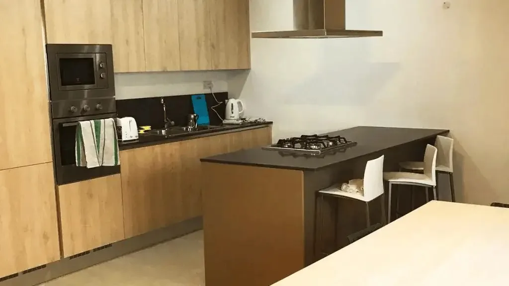 Residência ESE Astolat – Cozinha equipada Cozinha moderna da residência Astolat com ilha central e equipamentos integrados