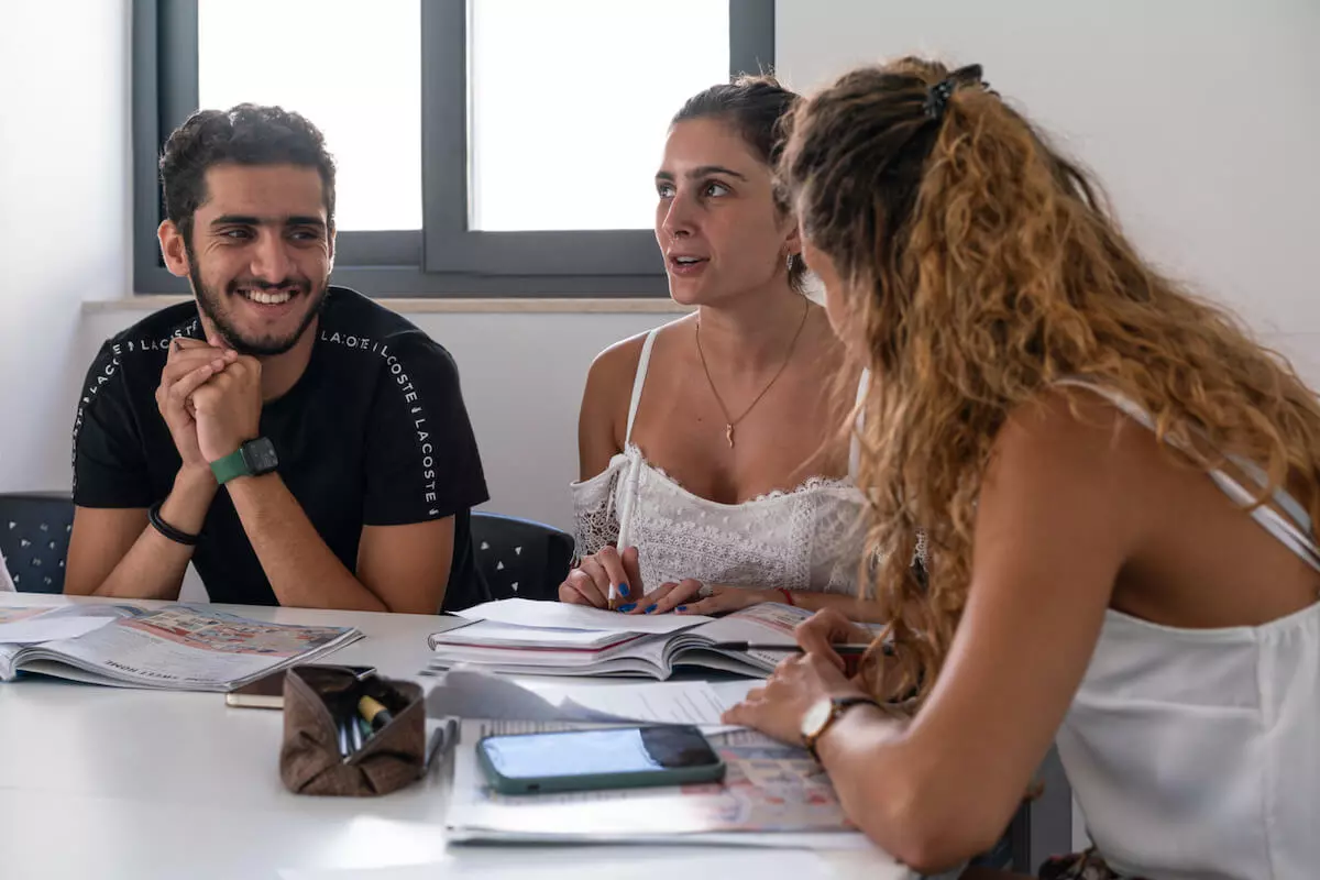 Trois étudiants adultes en cours d'anglais à l'EC