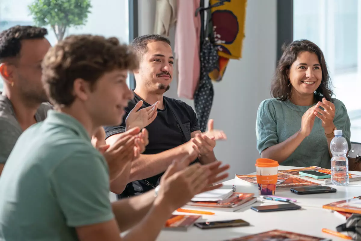 Groupe d'étudiants qui applaudisent leur professeur EC