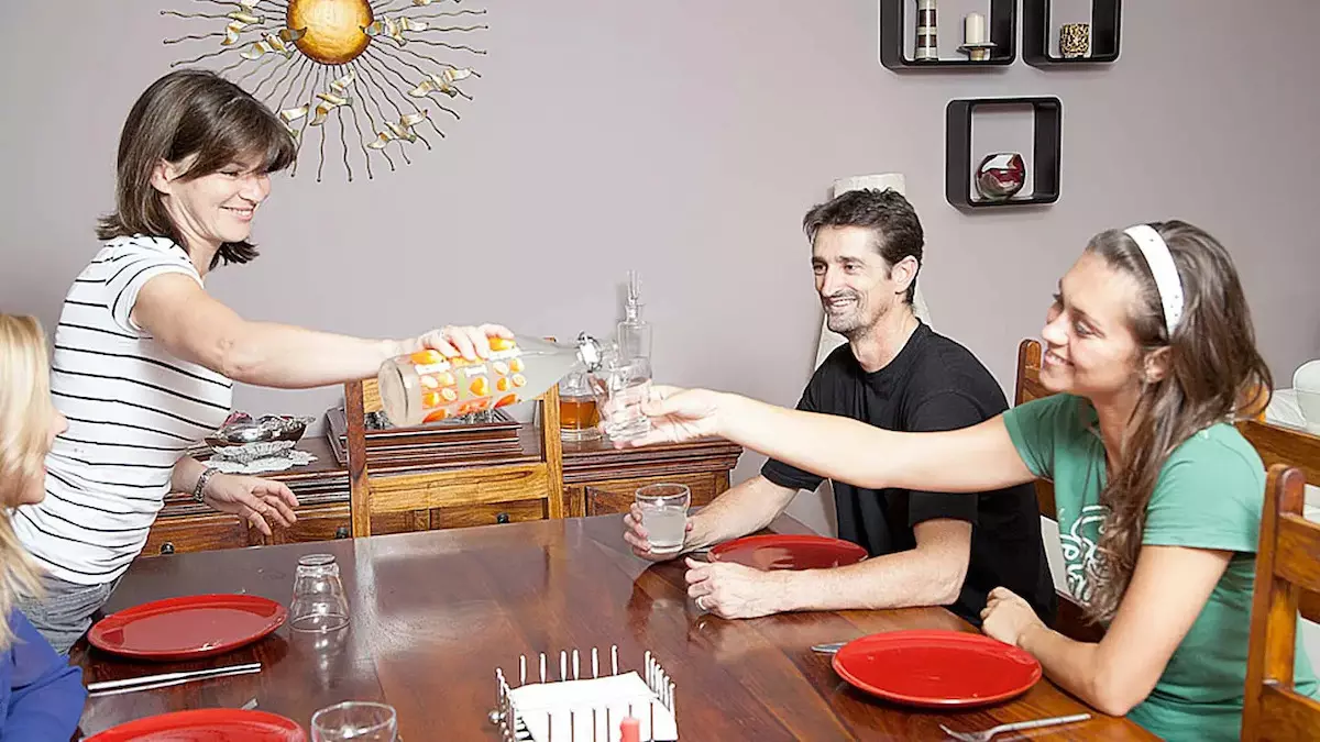 Dos estudiantes con su anfitrión de familia anfitriona durante una comida