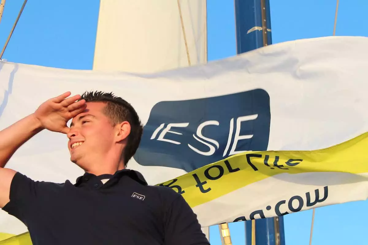 An ESE student on the boat with flag