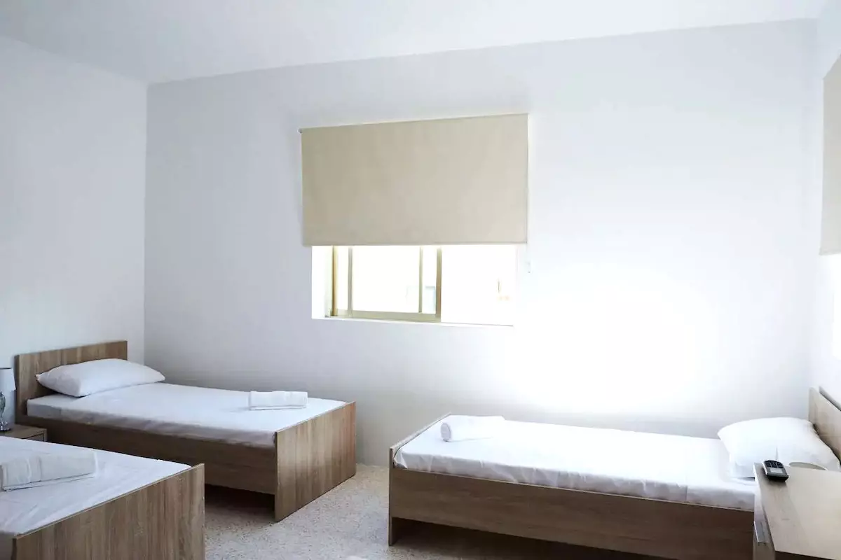 Quarto de um apartamento econômico da ESE com três camas