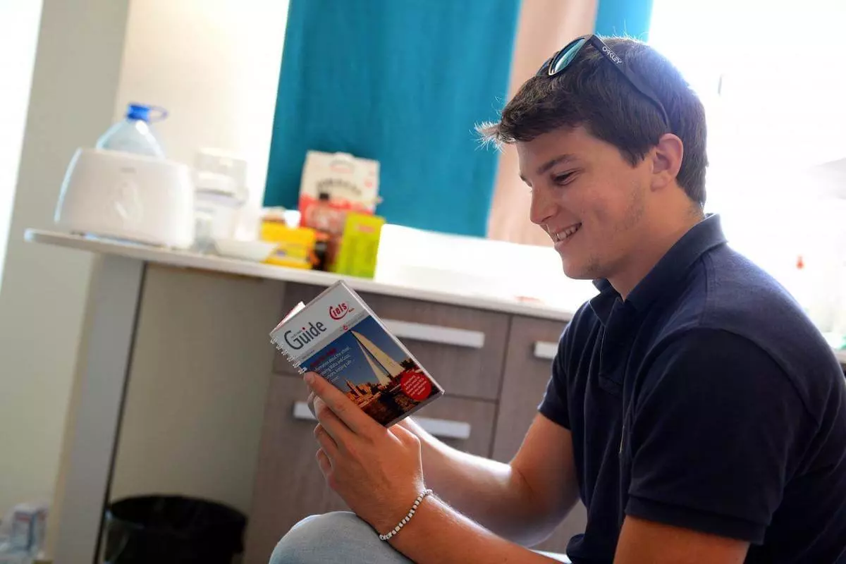 Um estudante com um livro de inglês em seu quarto no Day's Inn