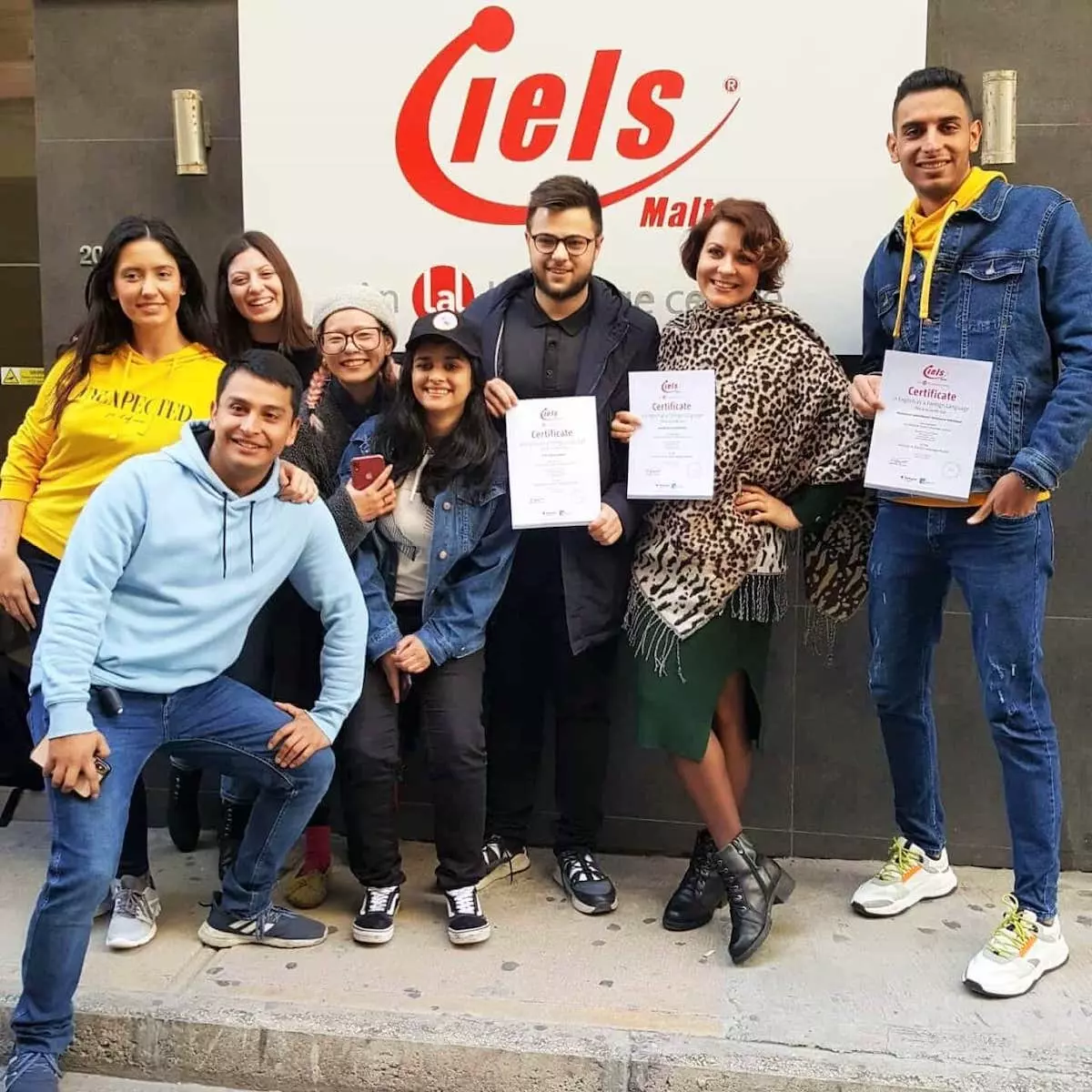 Grupo de 8 estudiantes con su diploma al finalizar su programa de idiomas en IELS Malta