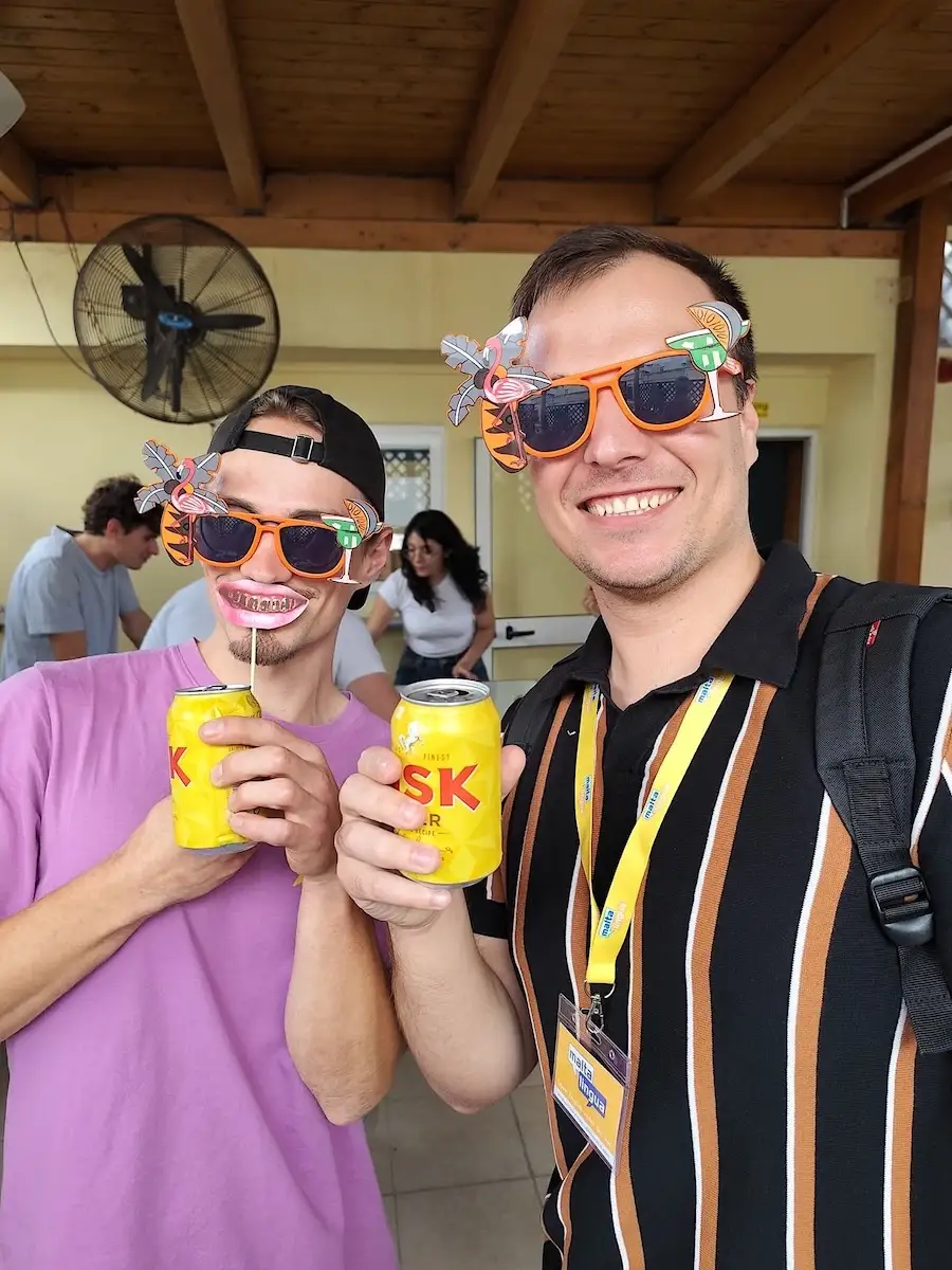Dos hombres con gafas divertidas y una cerveza Cisk en la mano