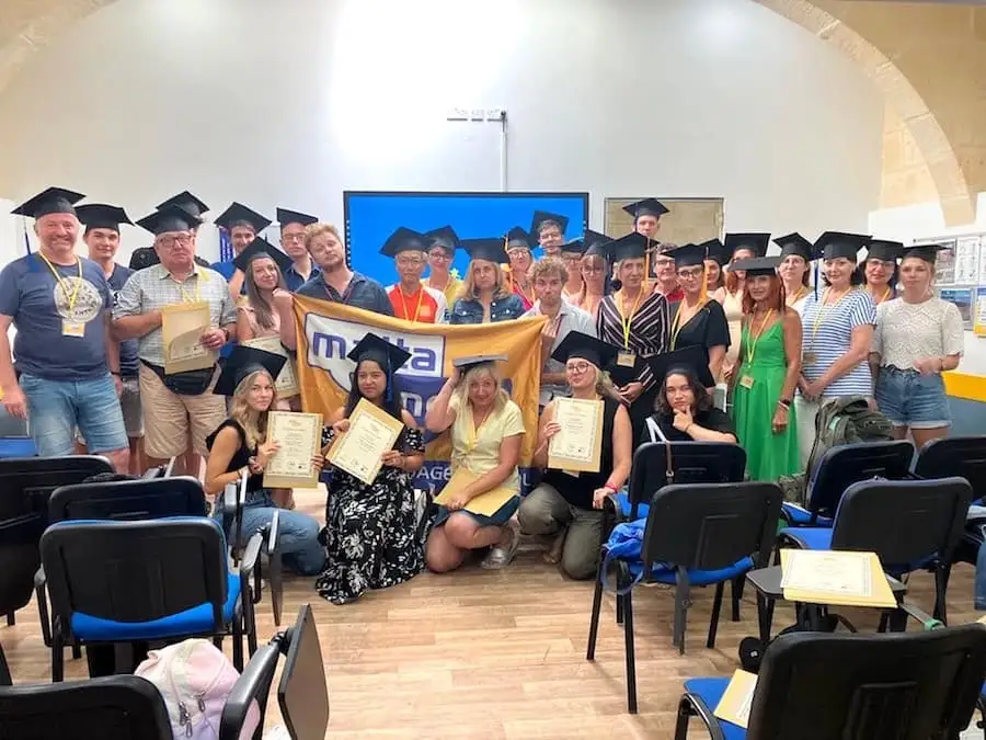 Estudiantes graduados de Maltalingua Grupo de estudiantes graduados con birretes negros