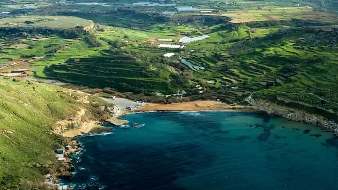 Пляж Ġnejna Bay с зелеными весенними окрестностями