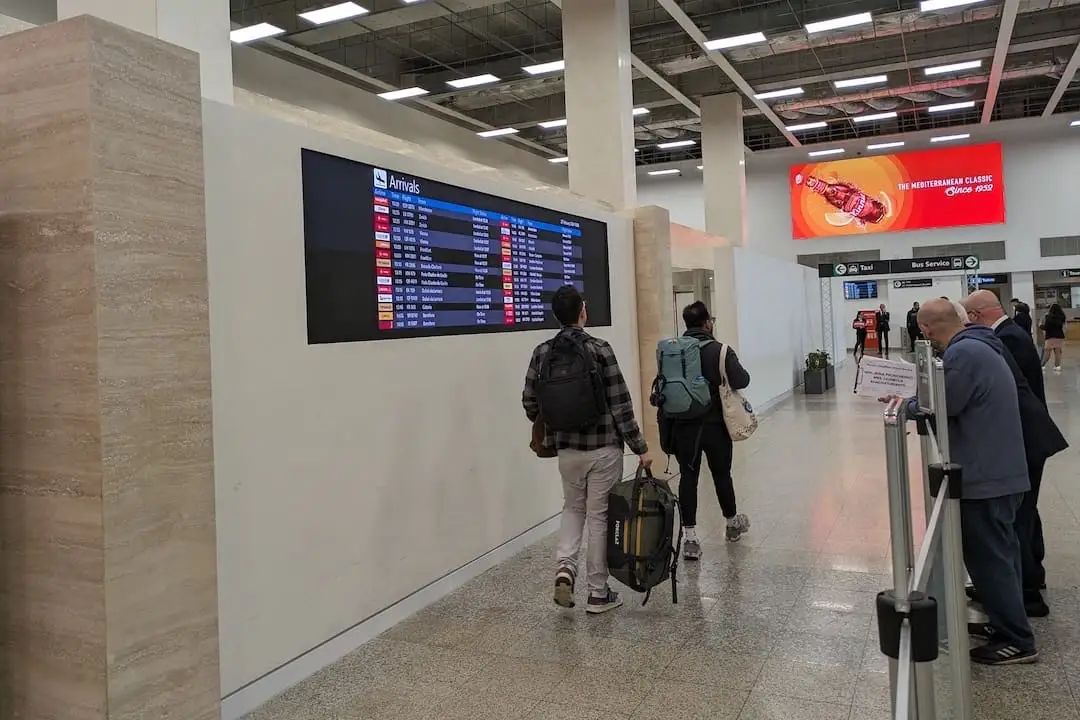 Dos viajeros de espaldas Salida de pasajeros del aeropuerto de Malta