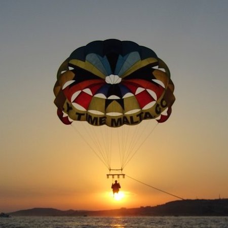 Una coppia in parasailing a Malta al tramonto