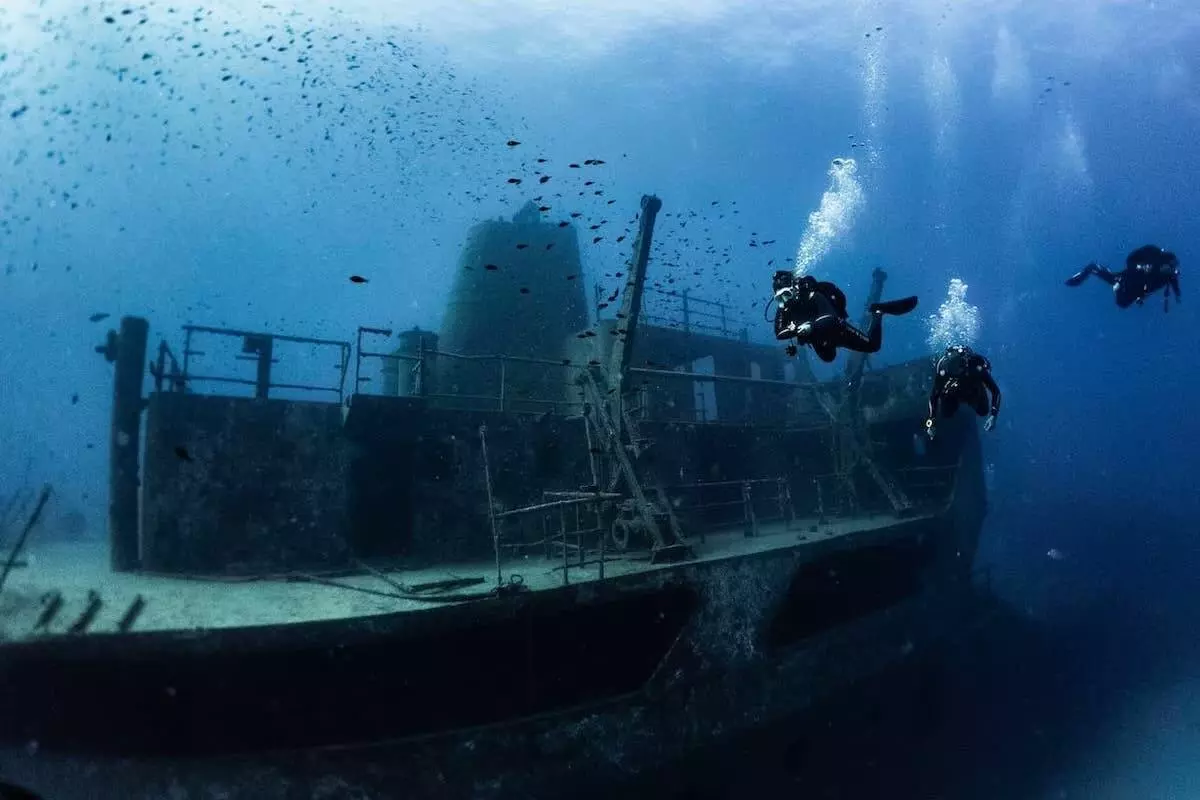 3 buceadores cerca de un pecio submarino en Malta