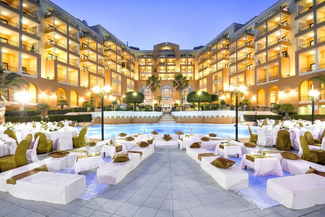 Inner courtyard with sofa and pool of Corinthia St George’s Bay