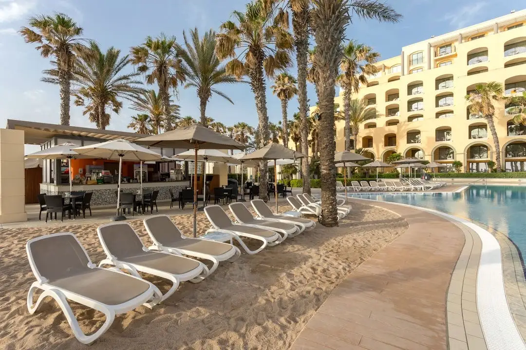 Outdoor pool with sand at Hilton Malta