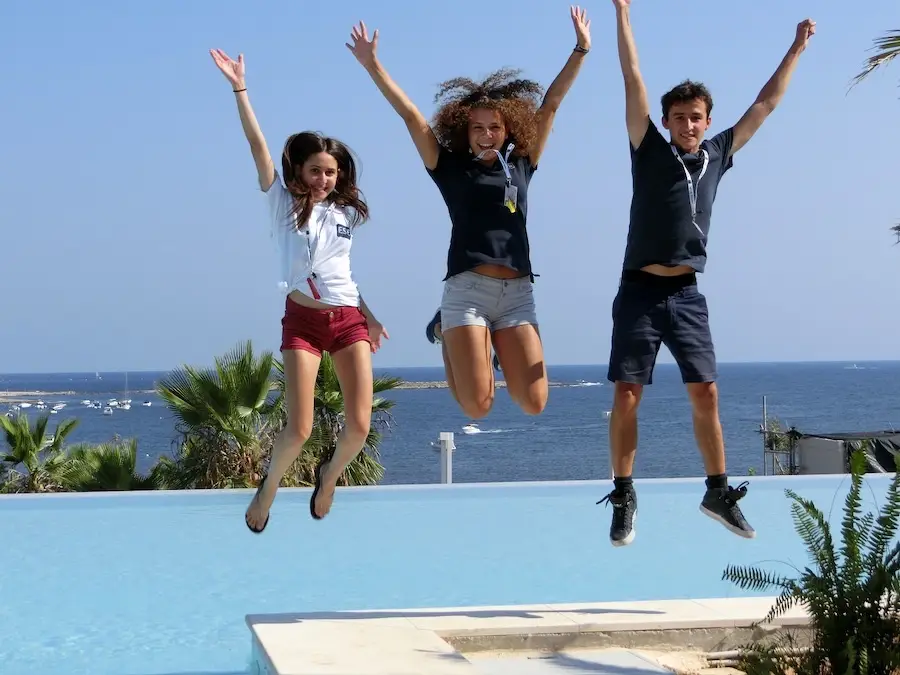 Team Leader séjour linguistique Malte Trois encadrants de l'ESE qui sautent devant la piscine du Salini
