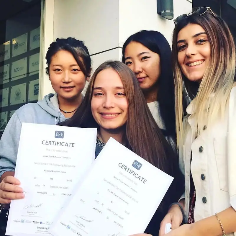 Quatre étudiantes souriantes avec leurs diplômes d'anglais