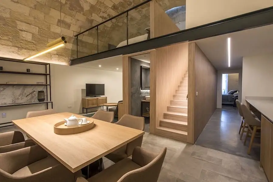 Amplia habitación superior con mesa y mobiliario del Cugó Gran Macina Malta