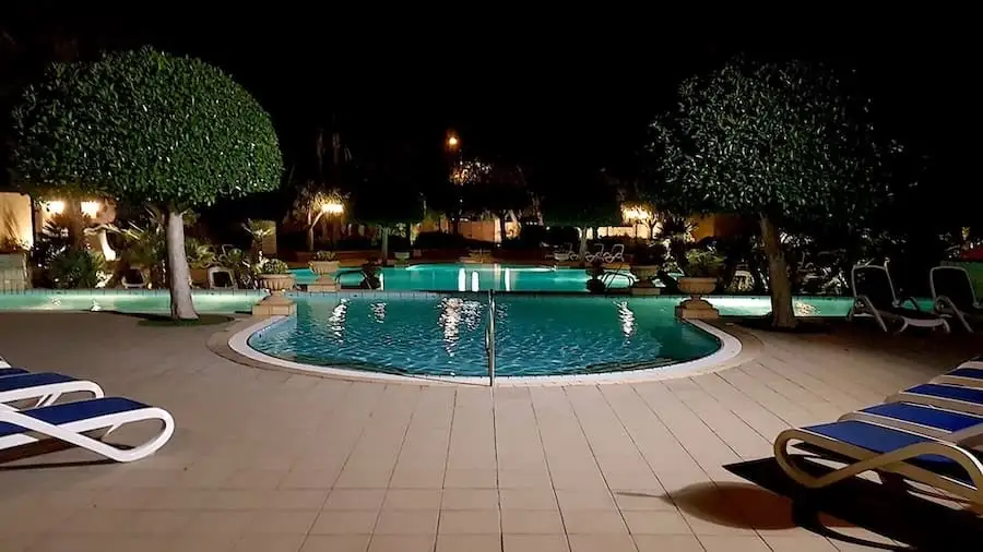 Piscina exterior de noche en el Corinthia Palace Malta