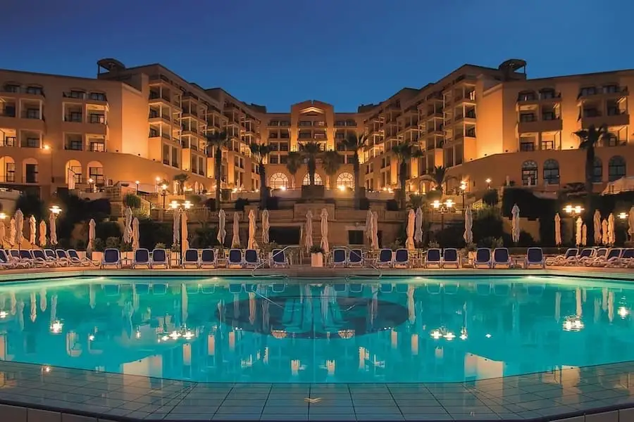 Piscina esterna di notte al Corinthia St George's Bay di Malta