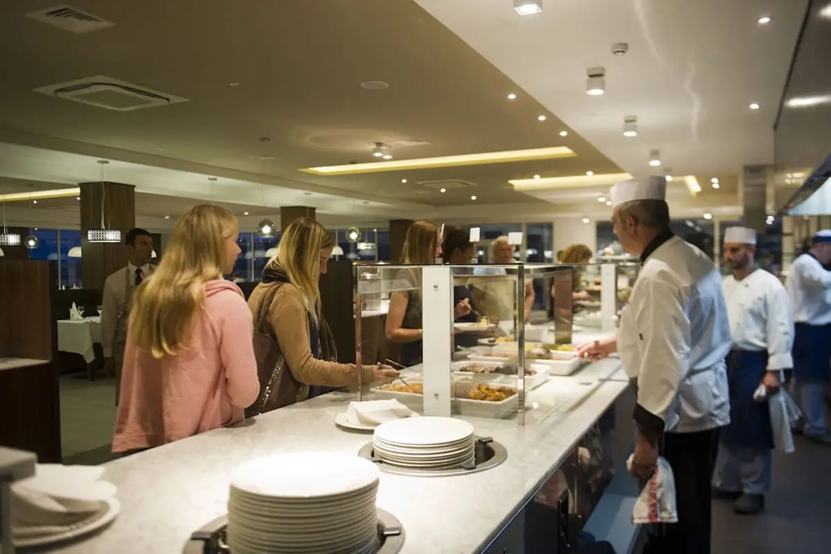 Young people helping themselves at the resort restaurant buffet during a language stay