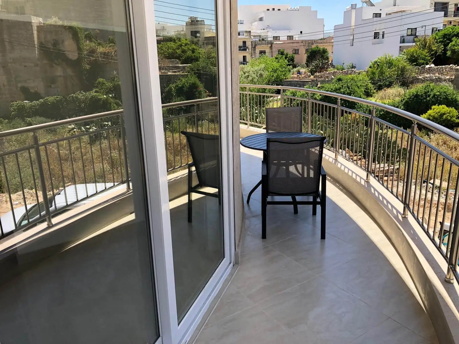 Balcony of an EC Malta apartment with table and chairs