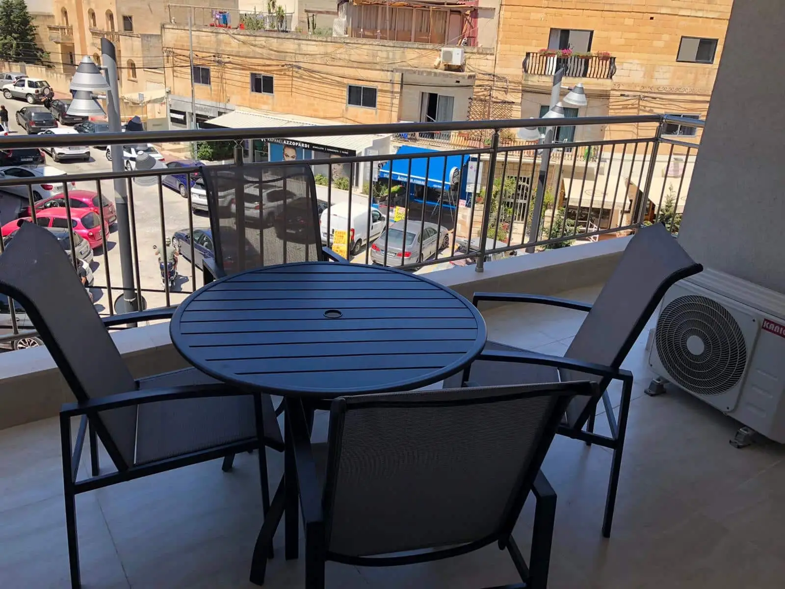 Terrace with table and chairs overlooking the street from EC Malta apartment