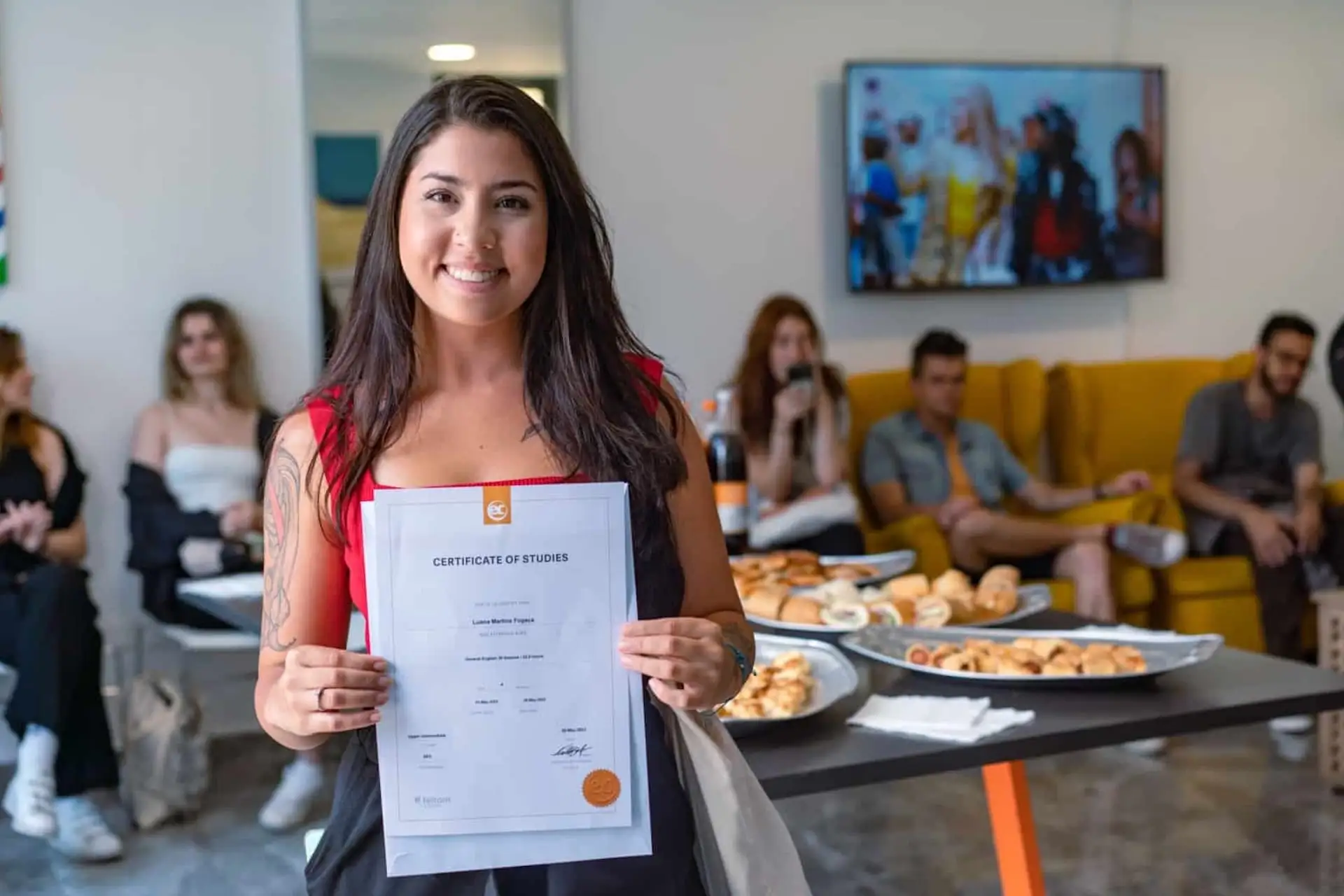 Smiling student holding her graduation certificate at EC Malta