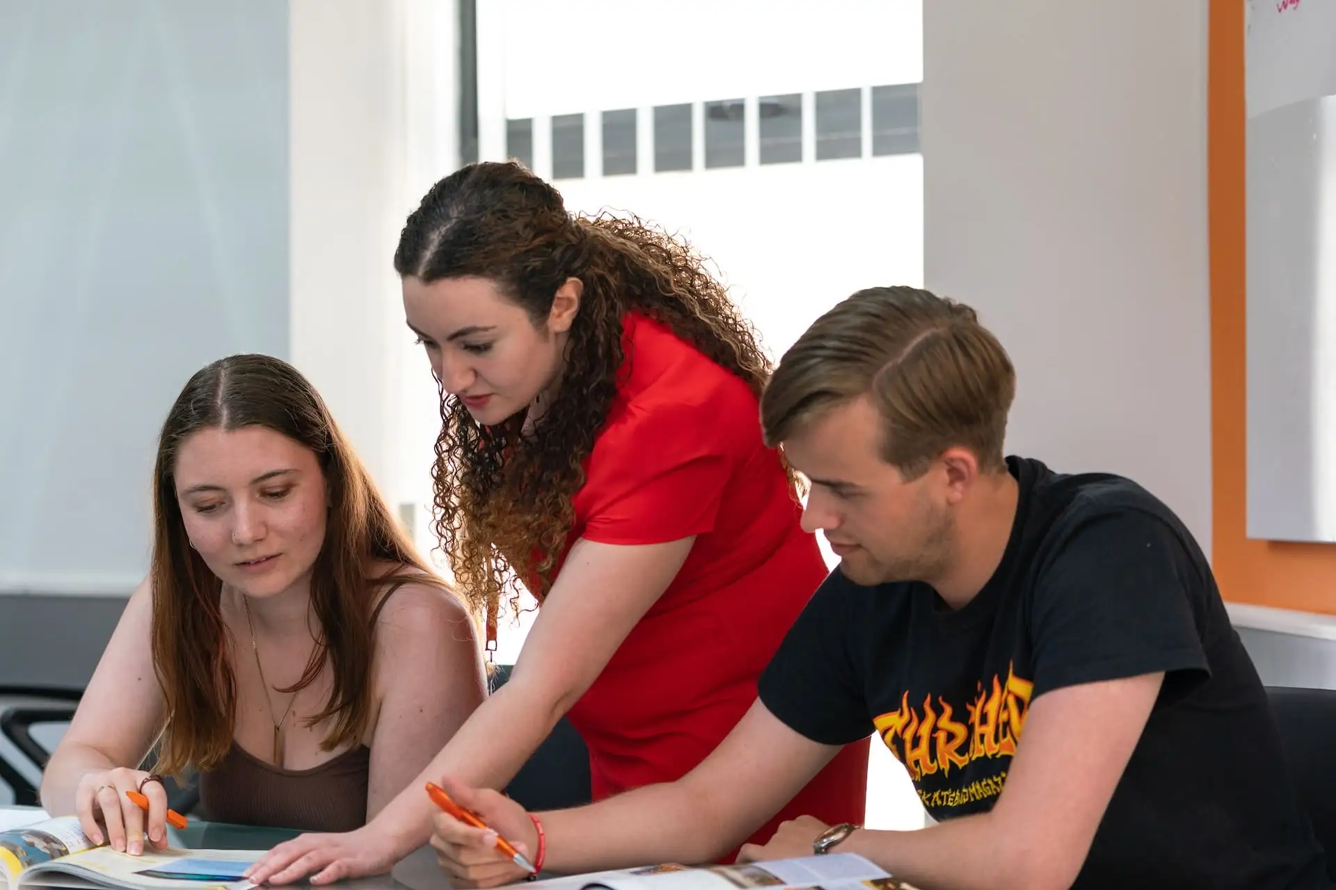 Teacher helping two students during an exercise at EC Malta