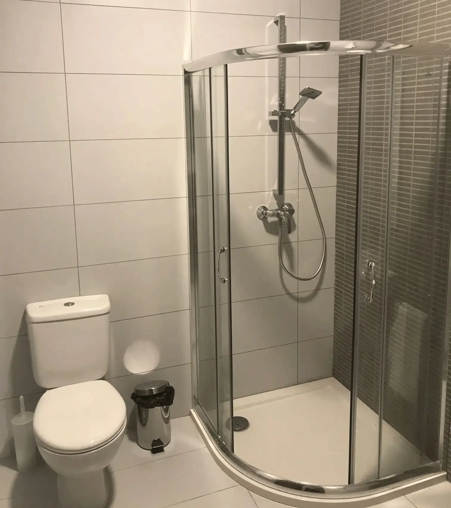 Salle de bain moderne de la résidence Astolat avec douche vitrée et WC