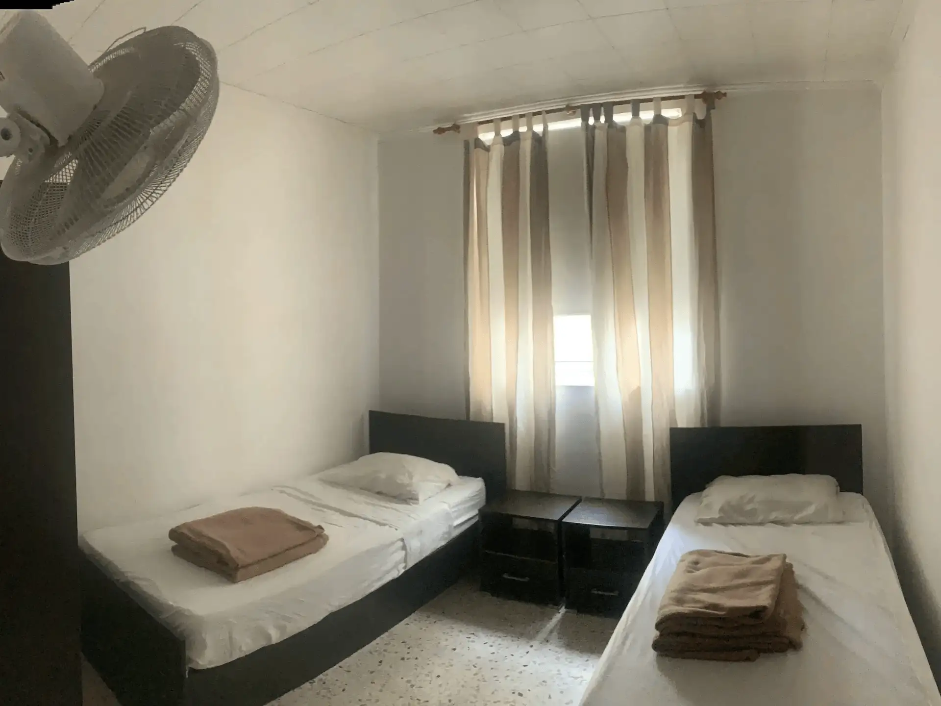 Chambre twin de la résidence Med Vista avec deux lits simples et mobilier en bois