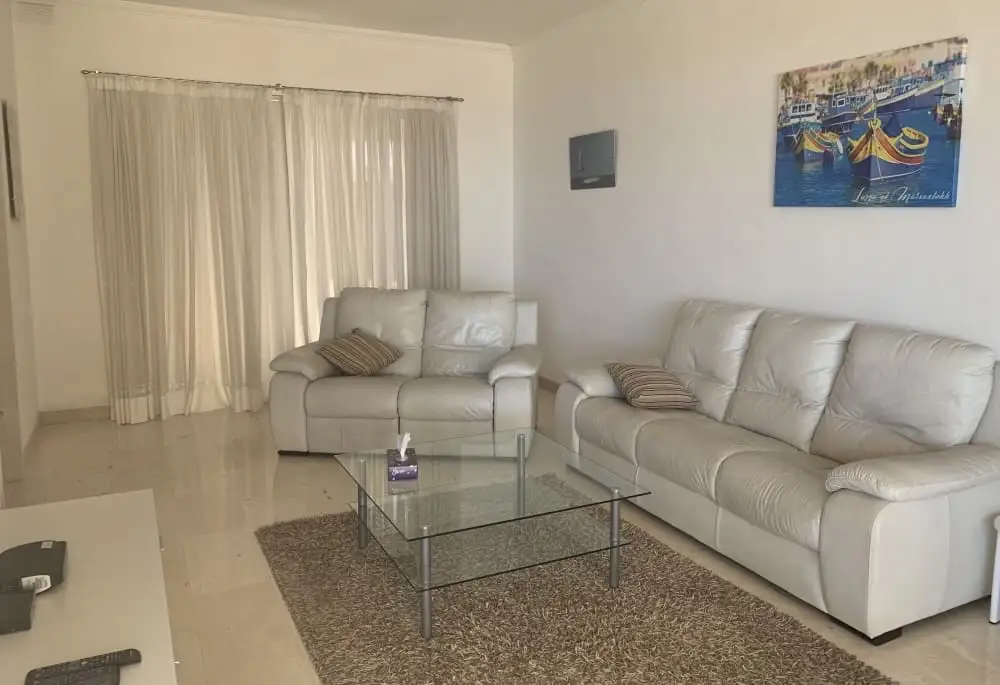 Salon lumineux de la résidence Med Vista avec canapés en cuir et table basse en verre