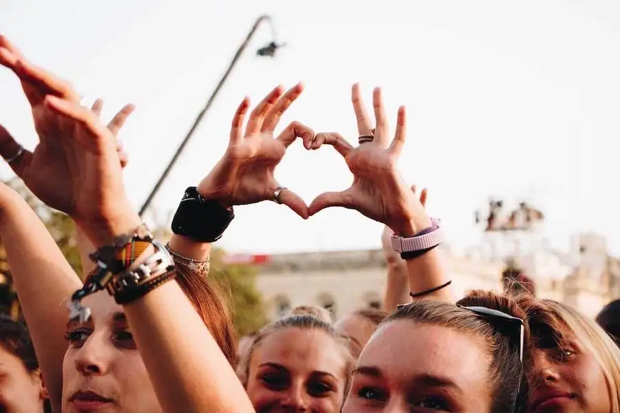 Students forming a heart with their hands during a concert in Malta