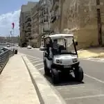 Pequeno carro audioguiado em frente às muralhas das Três Cidades