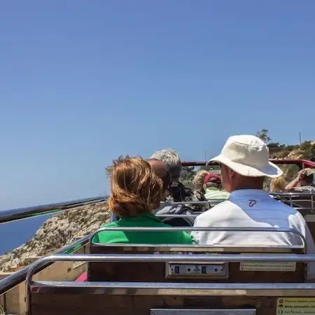 Passageiros em um ônibus turístico de frente para o mar em Malta