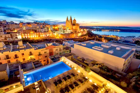 Pergola Hotel & Spa pool and view of the Parish Church of Mellieha (cheap hotel in Malta)