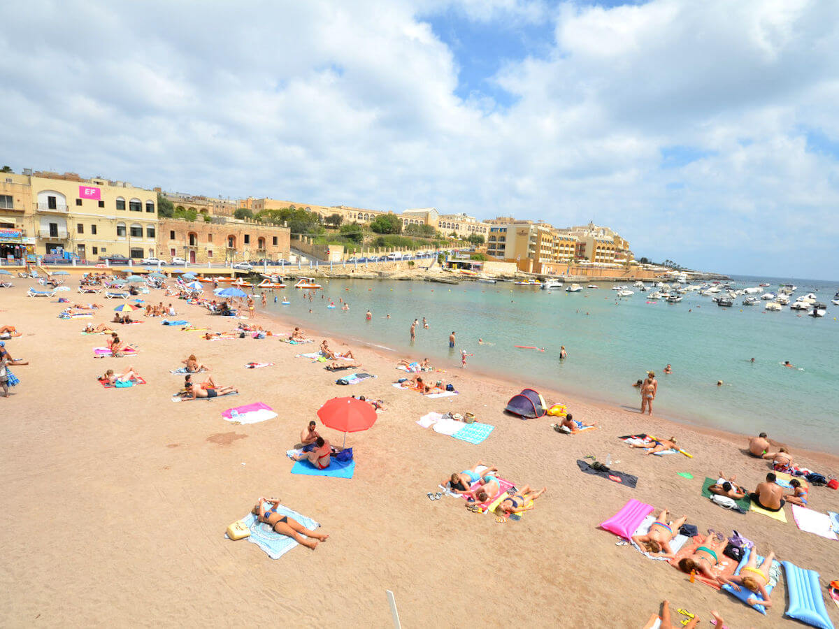 Sol e multidões recorde na praia de Golden Bay em Agosto - o tempo de Malta em Agosto é recorde de baixa