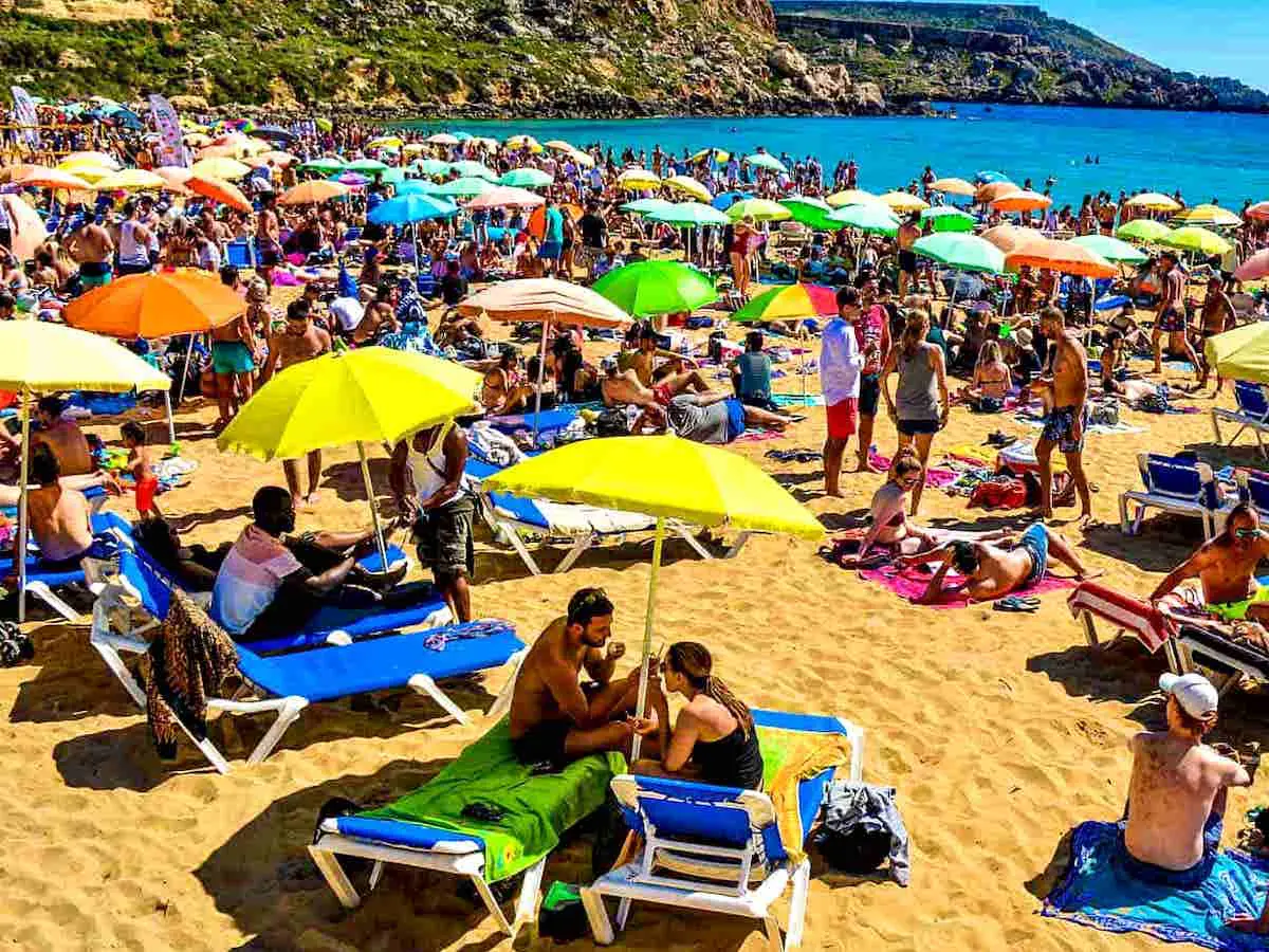 Sole e folla record sulla spiaggia di Golden Bay in agosto. Il tempo a Malta ad agosto è eccezionale