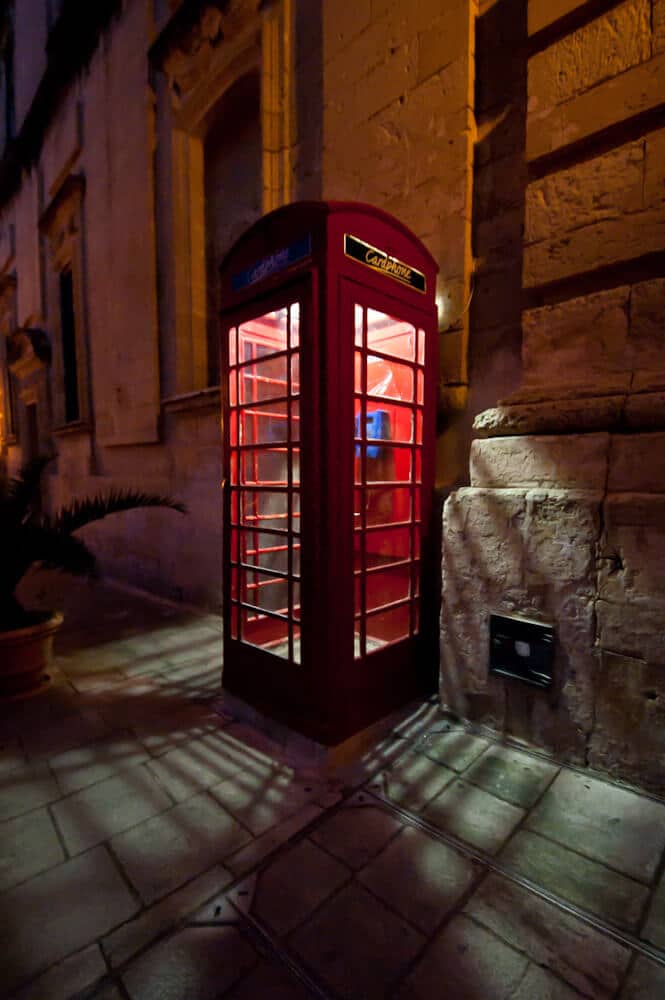 Cabine telefônica vermelha à noite em Mdina