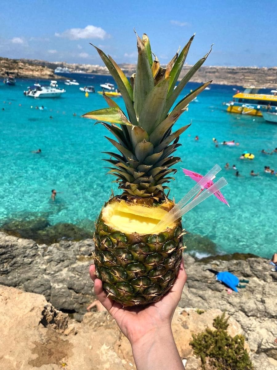 Cóctel de piña frente a la famosa Laguna Azul de Malta