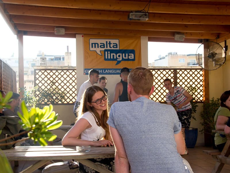 Dois estudantes conversando no terraço do telhado de Maltalingua